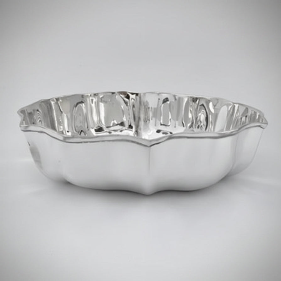 Silver bowl with wavy edge on a light gray background