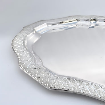Silver tray with decorative edge on a light gray background