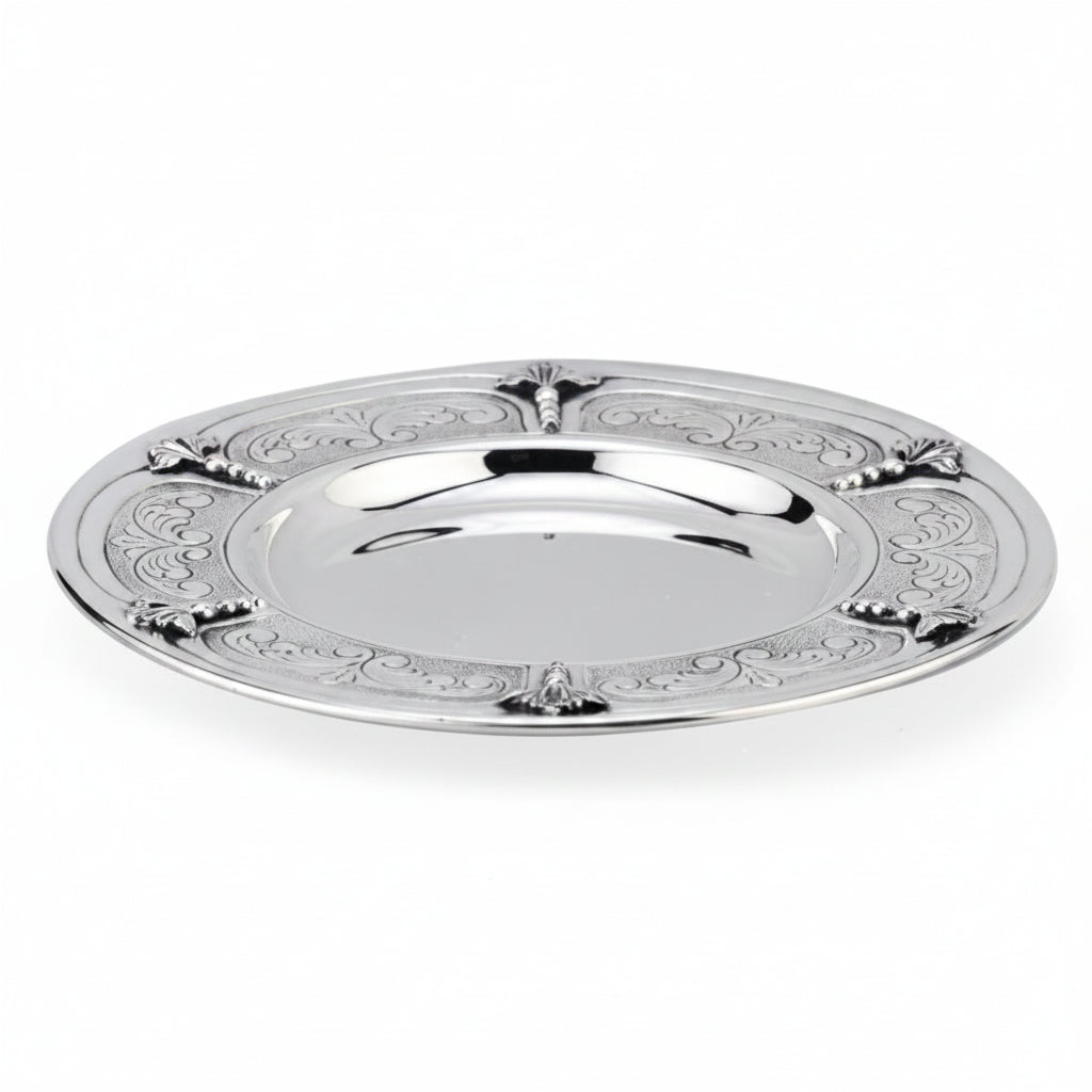 Silver kiddush cup with gold interior on a matching tray against a white background