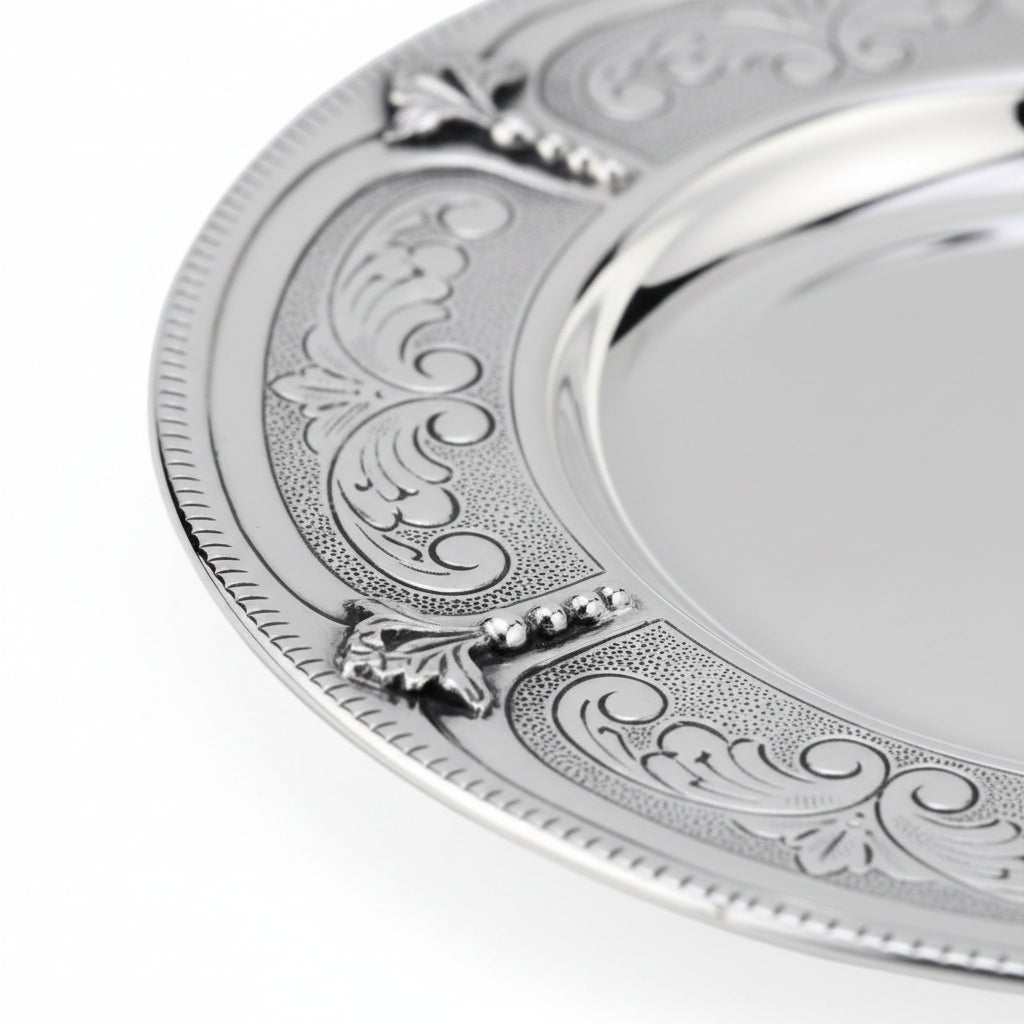 Silver and gold kiddush cup with ornate design on a white background
