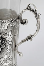 Close-up of an ornate silver cup with intricate designs on a white background