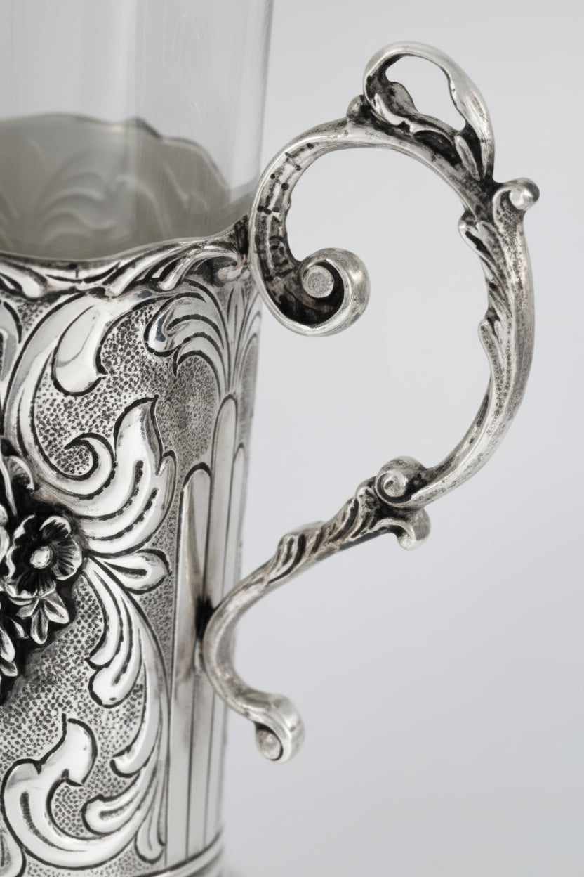Close-up of an ornate silver cup with intricate designs on a white background