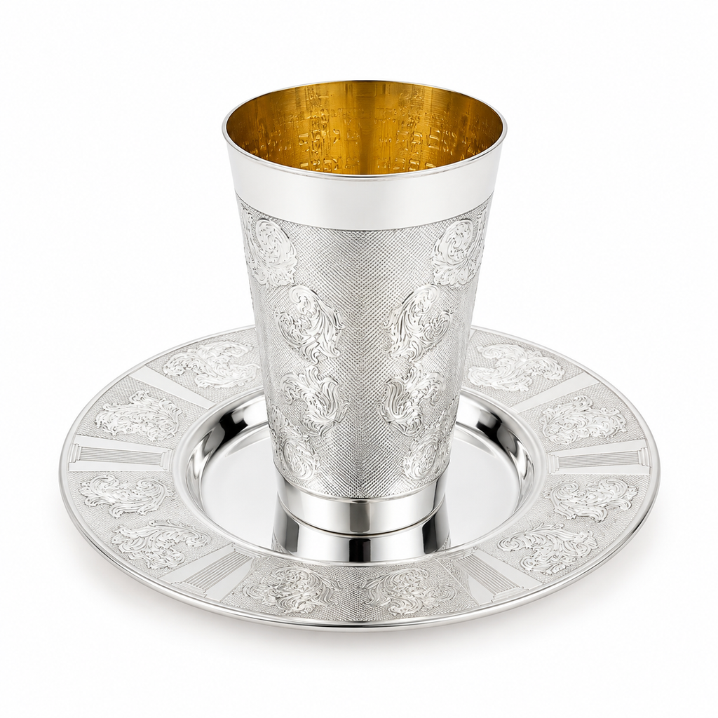 A silver Kiddush cup with an ornate floral engraving pattern, shown on a matching silver Kiddush plate by hadad bros silverware