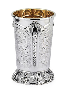 Silver kiddush cup with gold interior on a matching tray against a white background