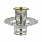 Silver kiddush cup mayim achronim with ornate design on a white background