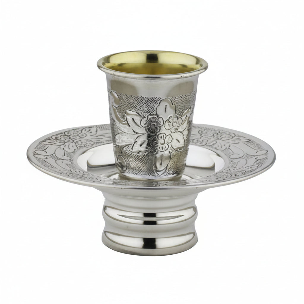 Silver kiddush cup mayim achronim with ornate design on a white background