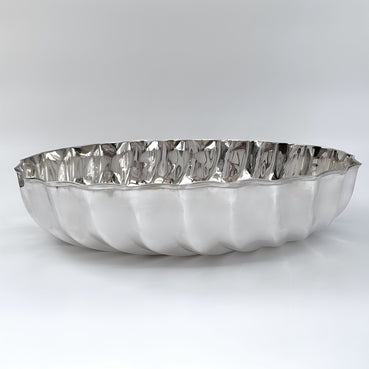 Silver decorative plate with wavy edge on a white background