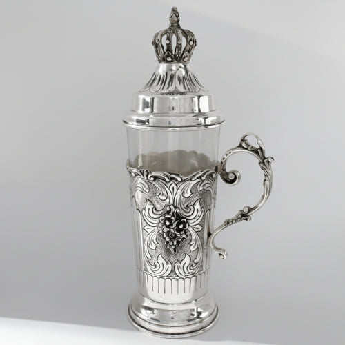 Silver teacup with intricate designs on a gray background