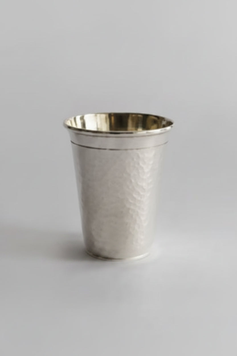 Metallic silver cup with hammered texture on a white background