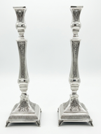 Pair of silver 925 candlesticks with intricate designs on a white background