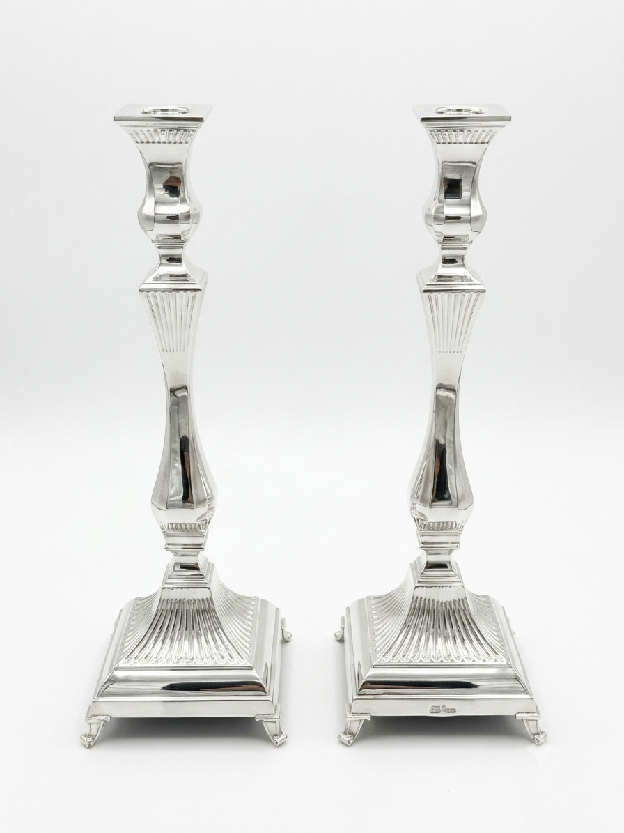 Pair of silver 925 candlesticks with intricate designs on a white background