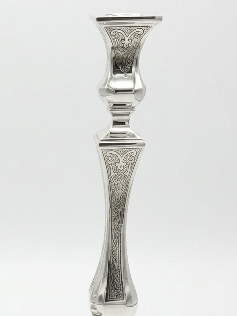 Pair of silver candlesticks with intricate designs on a white background