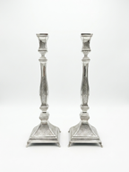 Pair of silver candlesticks with intricate designs on a white background by hadad bros
