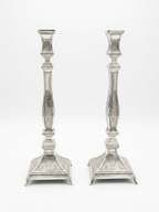Pair of silver candlesticks with intricate designs on a white background by hadad bros