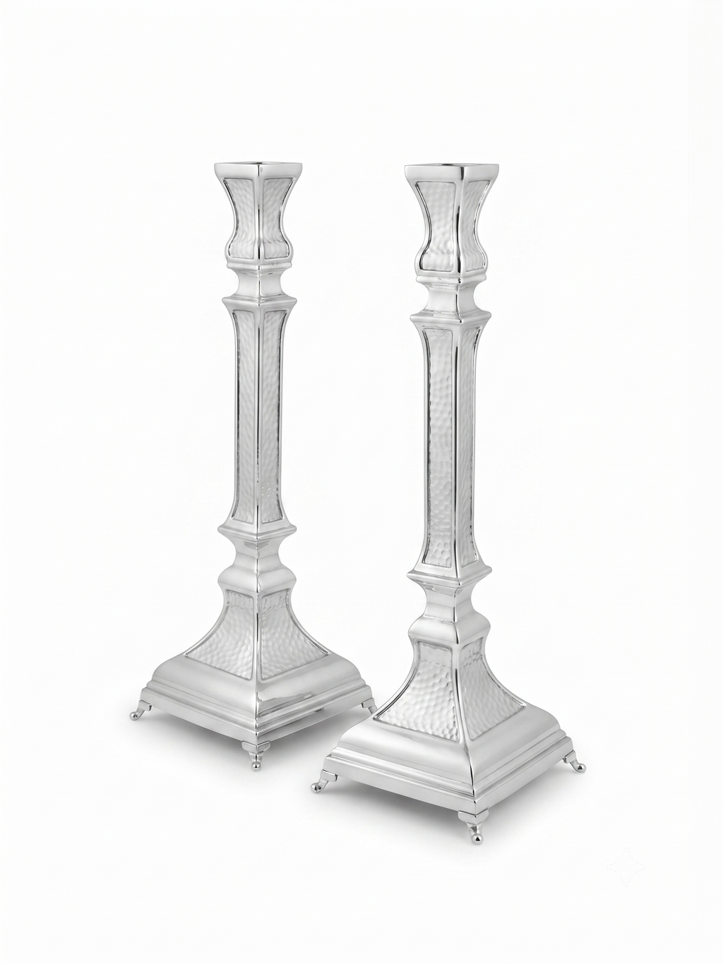A pair of ornate silver candlesticks with detailed textured engravings and flared bases, shown against a plain white background. hammered silver candlesticks by hadad bros silverware