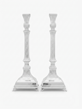 A pair of ornate silver candlesticks with detailed textured engravings and flared bases, shown against a plain white background. hammered silver candlesticks by hadad bros silverware