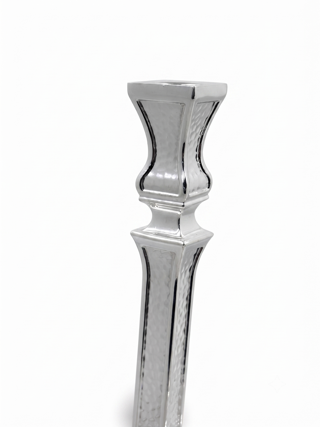 A pair of ornate silver candlesticks with detailed textured engravings and flared bases, shown against a plain white background. hammered silver candlesticks by hadad bros silverware