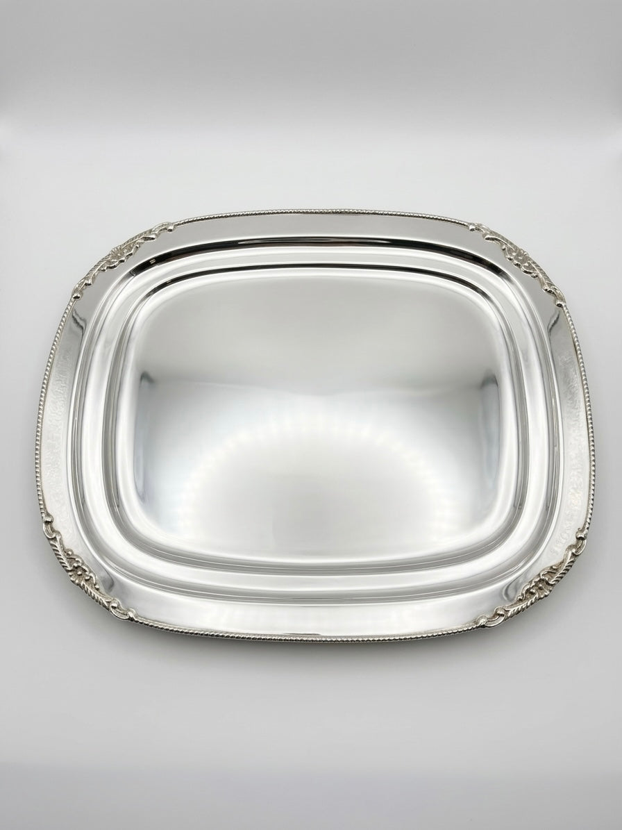 Silver platter with decorative edge on a light gray background