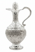 Silver pitcher with intricate design on a white background