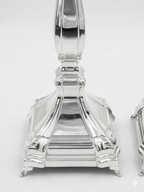 A pair of silver candlesticks with fluted stems and square bases, by hadad bros silverware