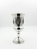 Silver goblet with intricate designs on a white background