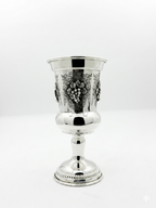 Silver goblet with intricate designs on a white background