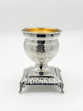 Silver and gold salt shaker cup on a white background