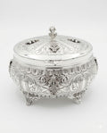 Decorative silver etrog box with intricate engravings on a white background