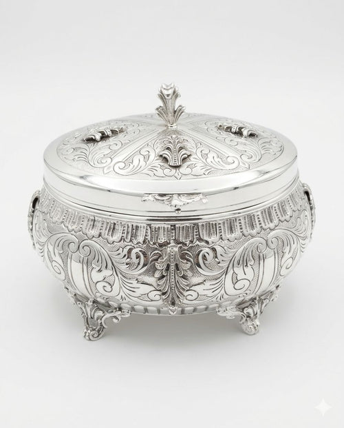 Decorative silver etrog box with intricate engravings on a white background