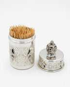 Decorative silver toothpick holder with wooden toothpicks on a white background