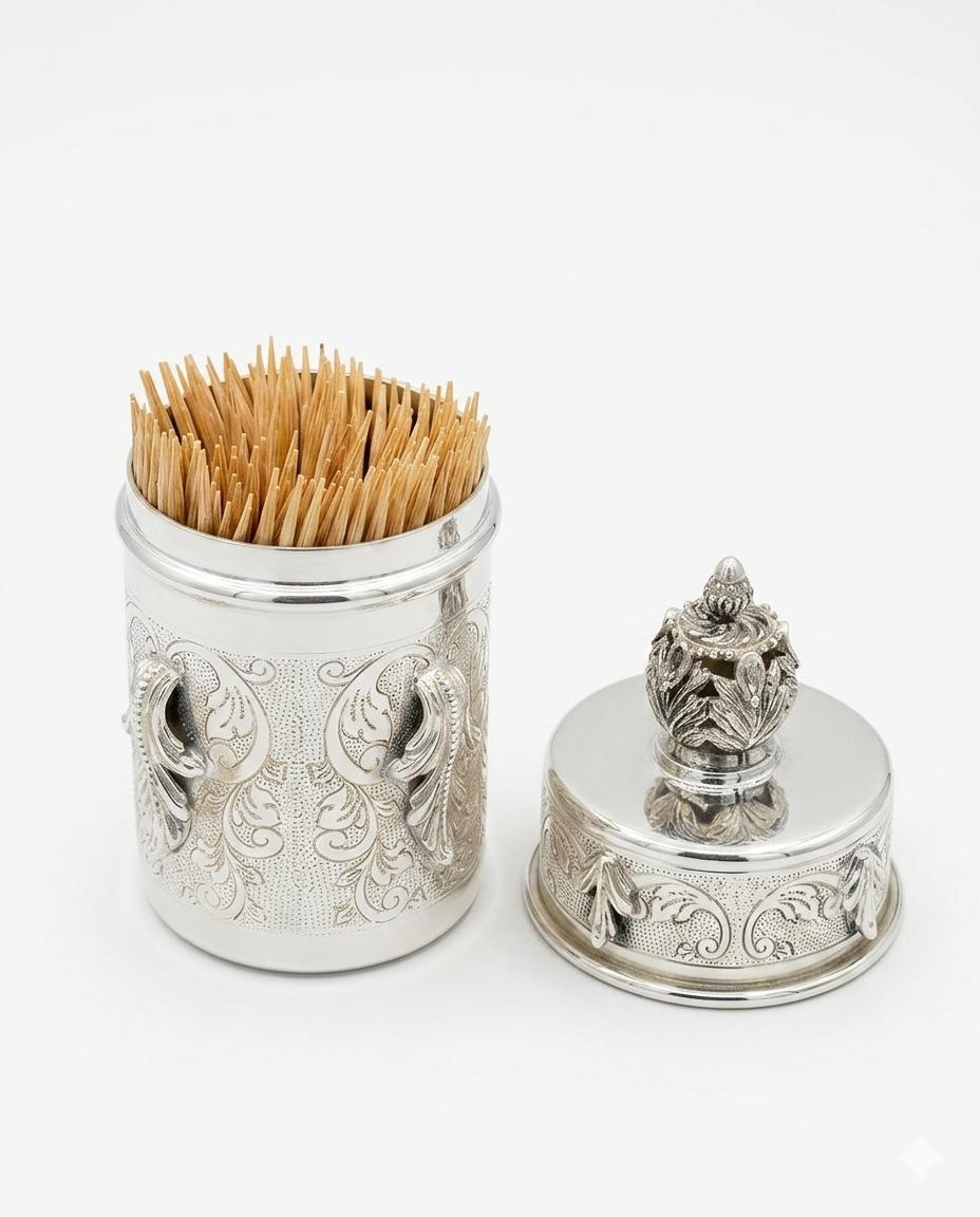Decorative silver toothpick holder with wooden toothpicks on a white background