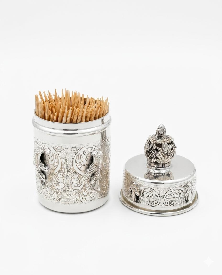 Decorative silver toothpick holder with wooden toothpicks on a white background