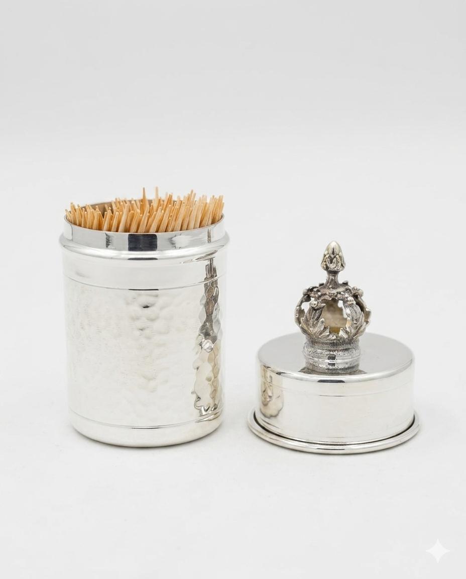 Silver toothpick holder with decorative top on a white background