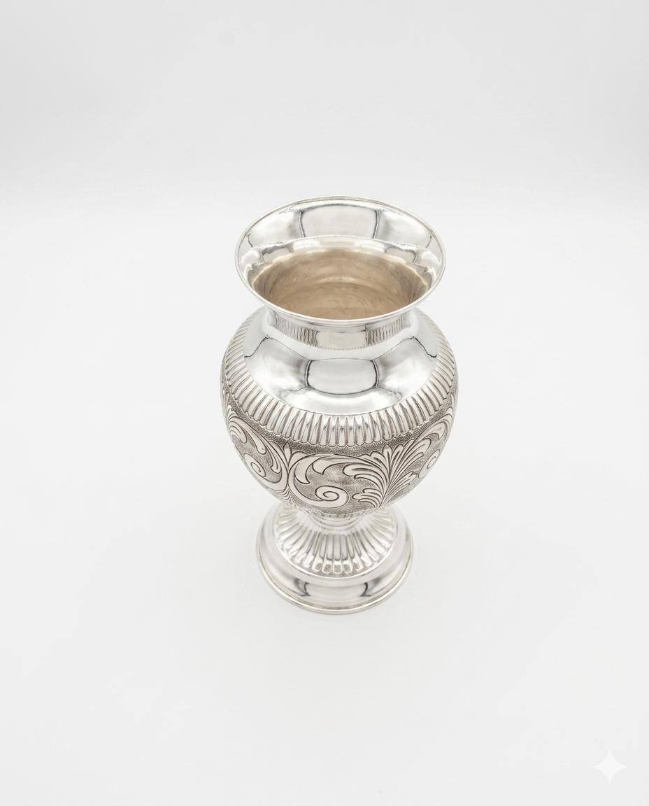 Silver vase with intricate patterns on a white background