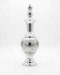 Silver decorative bottle with intricate designs on a white background