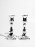 Two silver candle holders on a white background