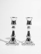 Two silver candle holders on a white background