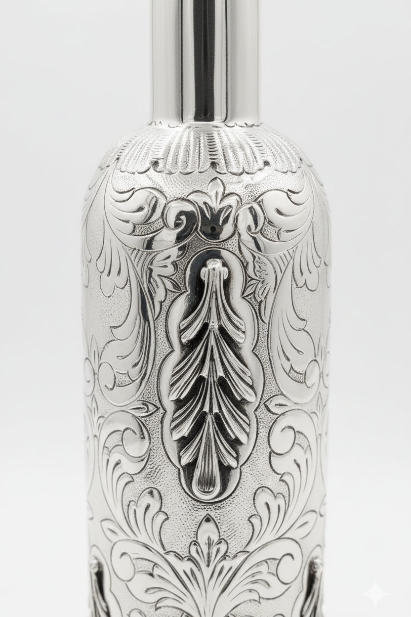 Silver bottle with intricate engravings on a white background