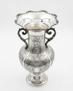 Silver vase with intricate designs on a white background