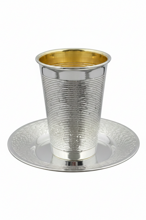 Silver and gold kiddush cup with matching saucer on a white background