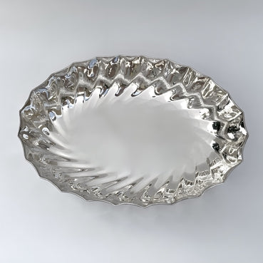 Silver decorative plate with wavy edge on a white background