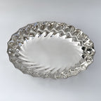 Silver decorative plate with wavy edge on a white background