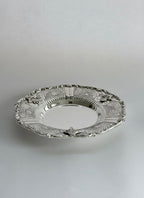 Decorative silver plate on a light gray background