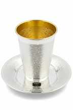 Silver and gold kiddush cup with saucer on a white background