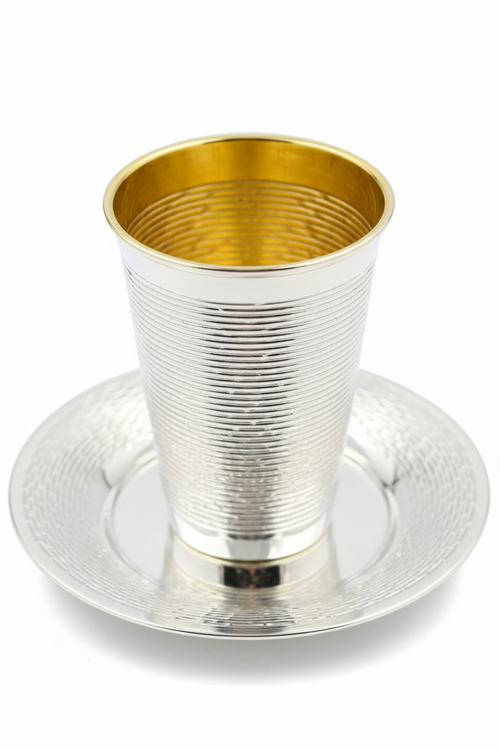 Silver and gold kiddush cup with saucer on a white background