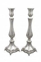 Two silver candlesticks on a white background