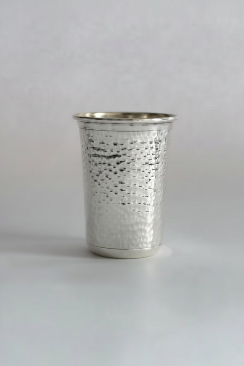 Metallic silver cup with hammered texture on a white background
